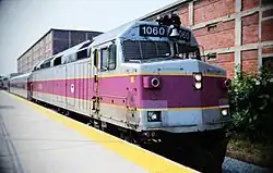 A passenger train with a diesel locomotive at a high-level platform