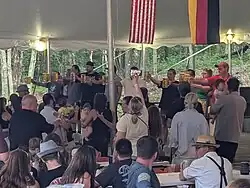 People standing on a platform holding full steins