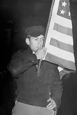 Black-and-white photo Koehl holding an American flag