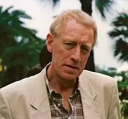 A profile image of Max von Sydow. An elderly Caucasian man with short white hair. He is facing forwards while looking off to the left, with a slight, open-mouthed smile.