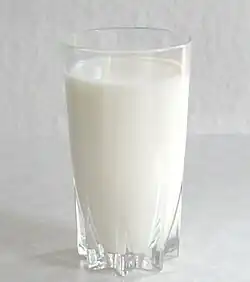 A red-capped bottle of milk with cream along the top.
