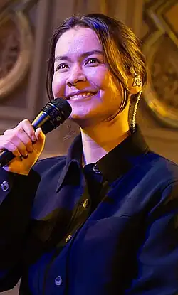 Mitksi smiling while holding a microphone.