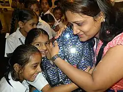 Children hug the 'calm lotus' sculpture to hear musical passages that create calm, 2014