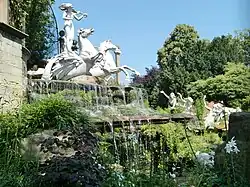 Profile view of complex showing cascade and dappling effect of reflections from the pool on the horses' wings