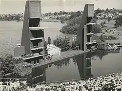 A black and white photograph of a group of performers on a stage in a lake