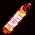 Glass tube shining orange light with a wire wound over it