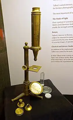 Compound microscope by Chevalier from the 19th century. Of the three accessories lying in front, the right one is a Lieberkühn reflector.