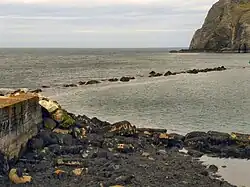 Rough line of rocks just above water level across a bay