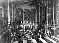 Black and white photo of the large main hall of the library, with tall bookshelves spanning multiple stories