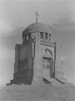 The Ostrach battle monument is a small, square building, raised from the ground about .5 meter, 8 meters high. A 3 meter dome, topped with a simple cross, caps the monument. It is of marble, with a simple double door.