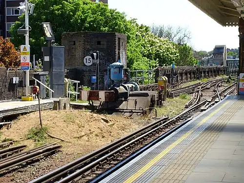 Southern end of the platforms at Putney Bridge station (2007 view), showing the former layout with reversing siding, the World War 2 pillbox defending the bridge, and the northern tip of the bridge