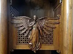 An angel on the front part of a confessional in a church as a metaphor of the seal of confession, Poland
