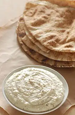 A bean dip prepared with white beans and Parmesan cheese, served with pita bread