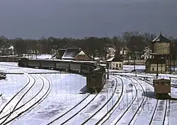 A rear view of a passenger train at a suburban station
