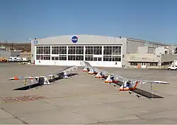 two craft in front of an aircraft hall