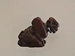A red jasper carving of a squatting Pazuzu, the crouching posture suggesting his connection to the West Wind.[15]