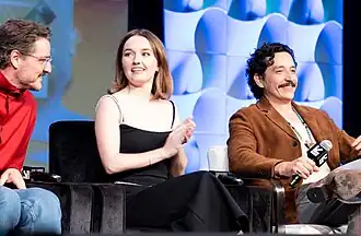Three people sitting on a stage