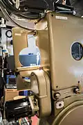 The non-operating side of the projector, showing the retrofitted motor for variable speed operation (bottom left). A viewing porthole (center right) enables the projectionist to confirm visually that oil is circulating while the mechanism is running.