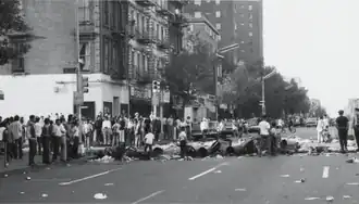 Black and white photo of garbage spread across a crowded New York City Street