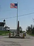 World War I veterans memorial in Pickrelltown (2010 photo). The 8&nbsp;ft (2.4&nbsp;m) high granite monument was erected in 1921, and has twice been rebuilt after vehicles crashed into it.[6][7]