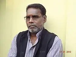 Tarai standing in front of a yellow wall