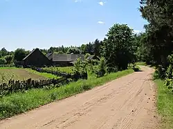 Houses by the unpaved road in Ożynnik