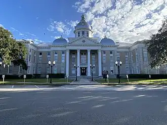 Large, white government building photographed from across the street