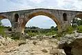 The dry riverbed of the Calavon and the main arch of the bridge