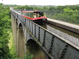 UNESCO World Heritage Site Pontcysyllte Aqueduct carrying the Llangollen Canal by civil engineers Thomas Telford and William Jessop in Wales, with a narrowboat crossing