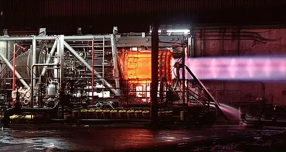 This picture of an uninstalled engine being tested illustrates the need for cooling air around the exhaust duct. The engine, when installed as part of the powerplant, has secondary cooling air at 1,200&nbsp;°F (650&nbsp;°C) passing over the afterburner duct which is heated internally by combustion up to 3,200&nbsp;°F (1,750&nbsp;°C). The heating, followed by the primary nozzle restriction, accelerates the exhaust to sonic speed as it leaves the primary nozzle (shown). The ejector nozzle (not shown) surrounds the primary exhaust with secondary and tertiary air to cushion its expansion in the ejector nozzle.