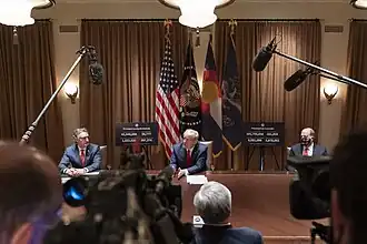 President Trump meets with Governors Doug Burgum and Jared Polis, with the North Dakota State Flag in the background.