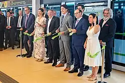 Multiple politicians posing in front of a REM train after the ribbon cutting