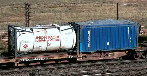 A spine car with a 20&nbsp;ft tanktainer and an open-top 20&nbsp;ft container with canvas cover