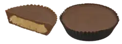 A whole Reese's Peanut Butter Cup next to a half Reese's Peanut Butter Cup showing the peanut butter filling in the middle of the Hershey's chocolate.