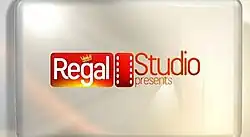 An image with the logo of the show on the center, over a gold colored background.
