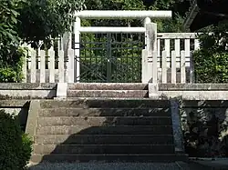 White torii beyond concrete fence.