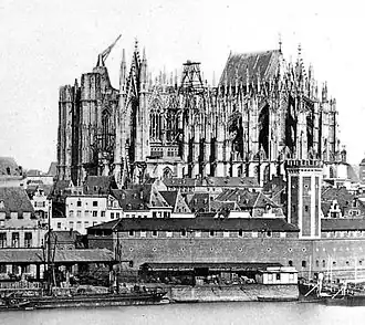 Old photo of the cathedral before completion shows the east end finished and roofed, while other parts of the building are in various stages of construction.