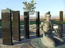 Statue of soldier bound on his knees surrounded by granite panels