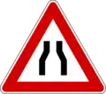 Road narrows on both sides