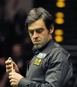 Ronnie O'Sullivan chalking his cue