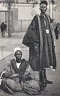 Senegal, early 20th century. A Wolof leader and his griot. The griot is holding an xalam (lute).