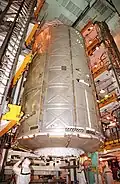 The US laboratory module being moved vertically from the payload transfer container to the Space Shuttle orbiter inside its installation structure