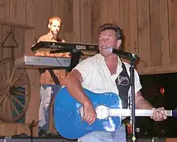 Country music singer Sammy Kershaw, singing and strumming a blue guitar