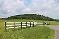 Fields, hills, woods, and a fence