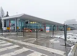 Photo of a glass panelled subway station and bus terminal behind protective fencing