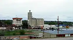 A multi-story building named the "Mill Inn" and tall grain elevator, seen from an elevated vantage point