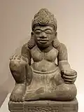 This seated figure may be a dharmapala. The pedestal below (not pictured) features an image of a kala head.
