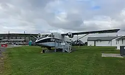 Stout looking airplane on a grass field with stairs leading to the entrance