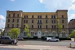 Four-story brick building with arched entrance with "Y" logo