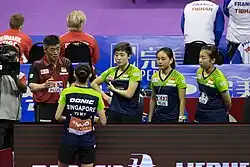 Four players standing listening to their coach.